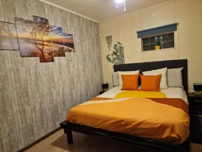 a bedroom with a bed with orange pillows at mignon in Soumagne