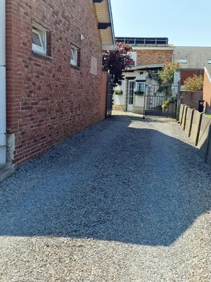 a driveway with gravel next to a brick building at mignon in Soumagne
