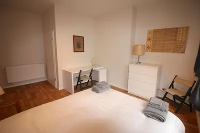 a bedroom with a bed and a desk and chairs at Appartement 3 chambres en plein centre ville in Liège