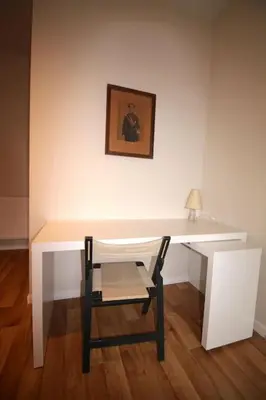 a desk with a chair and a picture on the wall at Appartement 3 chambres en plein centre ville in Liège