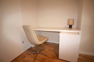 a white desk with a chair and a lamp at Appartement 3 chambres en plein centre ville in Liège