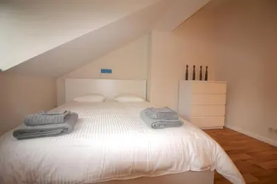 a bedroom with a white bed with towels on it at Appartement 3 chambres en plein centre ville in Liège
