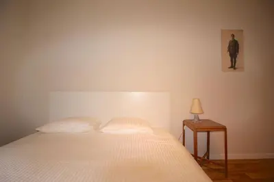 a bedroom with a bed and a table with a lamp at Appartement 3 chambres en plein centre ville in Liège