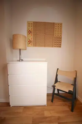 a room with a table and a chair and a lamp at Appartement 3 chambres en plein centre ville in Liège
