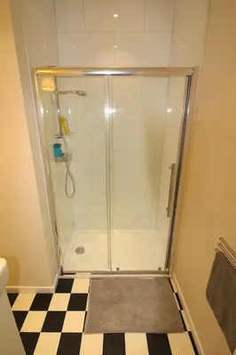 a shower in a bathroom with a checkered floor at Duplex de 3 chambres en plein centre ville - 82/3A in Liège