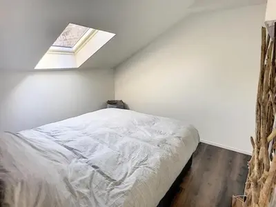 a bedroom with a bed with a window in it at Appartement 021 in Liège