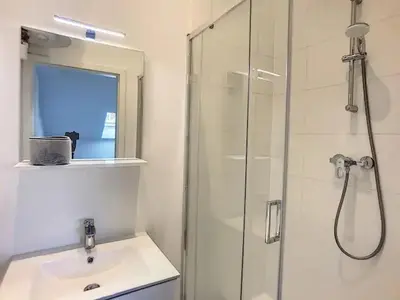 a bathroom with a glass shower and a sink at Appartement 021 in Liège