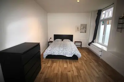 a bedroom with a bed with a black and white bedspread at Bel appartement 2 chambres avec terrasse in Liège