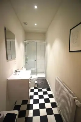 a bathroom with a black and white checkered floor at Bel appartement 2 chambres avec terrasse in Liège
