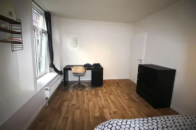a room with a bedroom with a desk and a chair at Bel appartement 2 chambres avec terrasse in Liège
