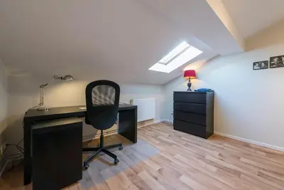 an attic office with a desk and a chair at Appartement 4 chambres à Liège in Liège