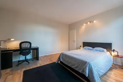 a bedroom with a bed and a desk and a chair at Appartement 4 chambres à Liège in Liège