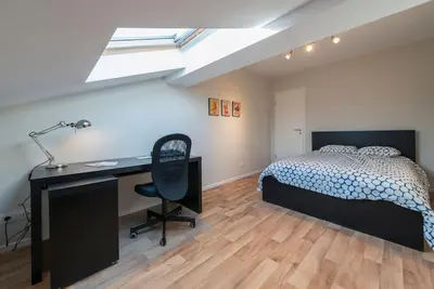 a bedroom with a bed and a desk and a desk at Appartement 4 chambres à Liège in Liège