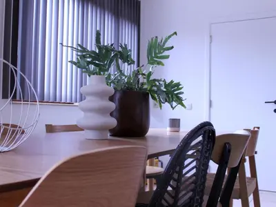a wooden table with a vase with a plant on it at Retreat near Maasmechelen in Lanaken