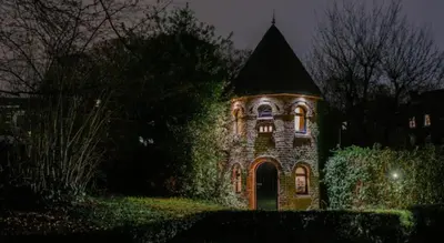 a large brick building with lights on it at night at Le pigeonnier - TinyHouse en plein centre de Liège in Liège