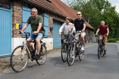 three men riding bikes down a street at Vakantiewoning De Luysmolen in Bocholt