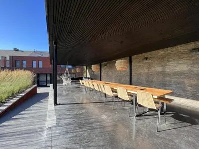 a long wooden table and chairs on a patio at Bigaro II in Heers