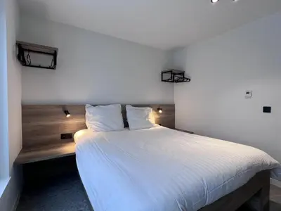 a bedroom with a large bed with white sheets at Bigaro II in Heers