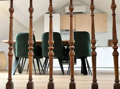 a dining room with green chairs and a table at Duplex hyper centre in Liège