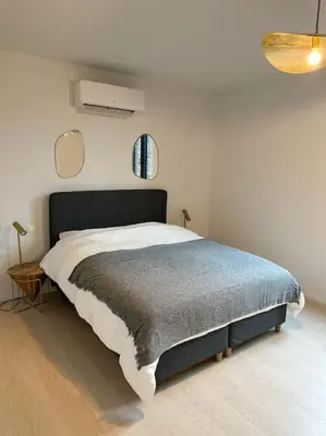 a bedroom with a bed in a white room at Duplex hyper centre in Liège