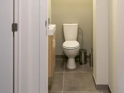 a bathroom with a toilet and a sink at Maasmechelen Duplex Retreat in Maasmechelen
