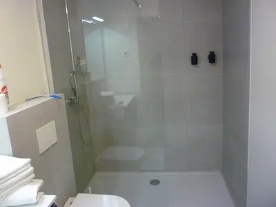 a bathroom with a shower with a toilet and a sink at De Hoog Velden 15 in Overpelt