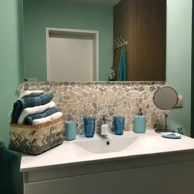 a bathroom sink with a basket of towels and a mirror at Casa Sandra Elisa in Maasmechelen