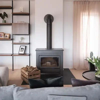 a living room with a fireplace and a couch at MAM Haspengouw in Sint-Truiden