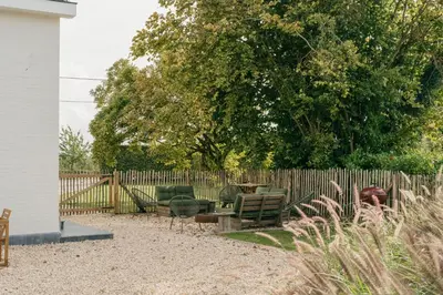 a yard with chairs and a fence with a tree at MAM Haspengouw in Sint-Truiden