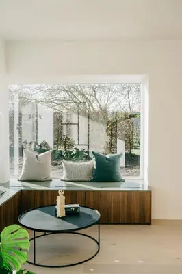 a table in front of a window with pillows at MAM Haspengouw in Sint-Truiden