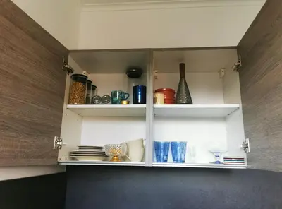 a cupboard with plates and dishes in it at Studio Montaigne in Liège