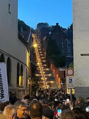 a crowd of people walking down a street with lights at Studio Montaigne in Liège