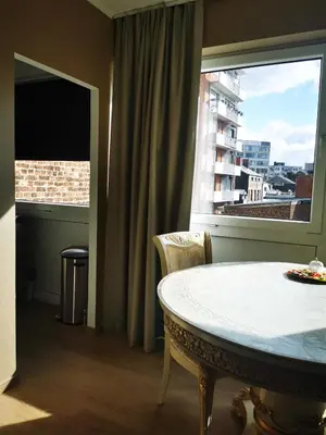 a room with a table and a large window at Studio Montaigne in Liège
