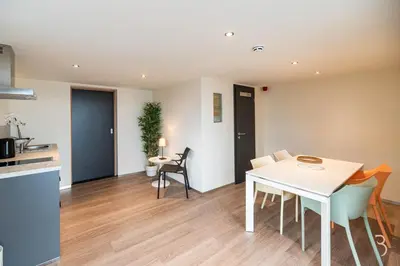 a kitchen and dining room with a table and chairs at Smart Bnb - Appart Hotel Battice in Herve
