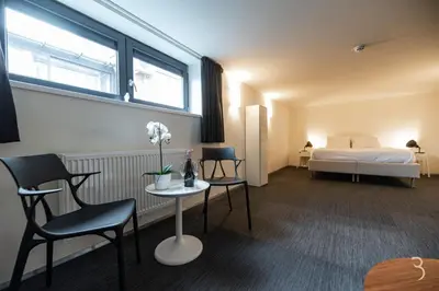 a room with a bed and a table and chairs at Smart Bnb - Appart Hotel Battice in Herve