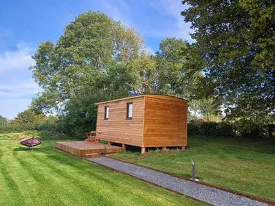 a small cabin in the middle of a grass field at La roulotte de Soiron in Pepinster