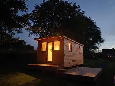 a small tiny house with lights on it at night at La roulotte de Soiron in Pepinster