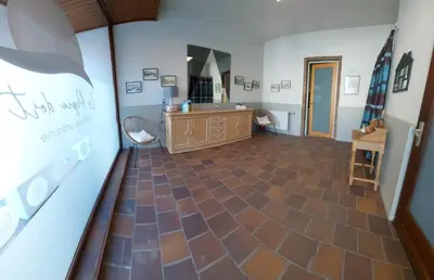 a large room with a bathroom with a sink and a mirror at Le Pepin Dort in Pepinster