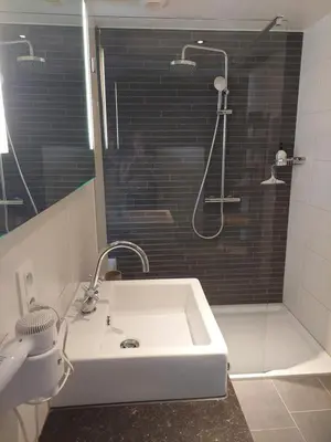a bathroom with a white sink and a shower at La chambre et le studio du château du golf de Bernalmont in Liège