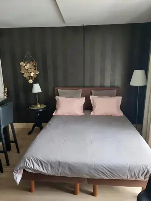 a bedroom with a large bed with pink pillows at La chambre et le studio du château du golf de Bernalmont in Liège