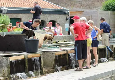 a group of people standing next to a water fountain at Arcaden loft in Sint-Martens-Voeren