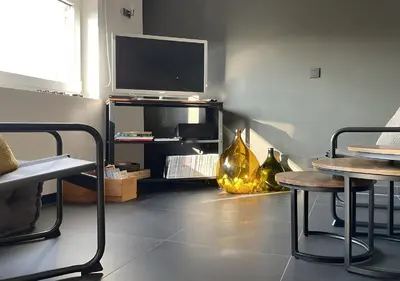 a living room with a tv and a table and chairs at Arcaden loft in Sint-Martens-Voeren