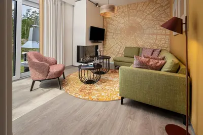 a living room with a couch and chairs and a tv at Terhills Resort by Center Parcs in Dilsen-Stokkem
