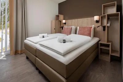 a large bed in a hotel room with a large white bed at Terhills Resort by Center Parcs in Dilsen-Stokkem
