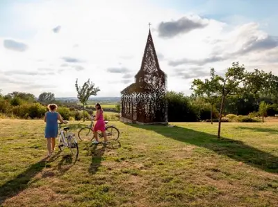 a man and a woman with a bike in a field at Ca'Triz in Borgloon