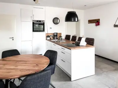 a kitchen with a wooden table and some chairs at Hof Gemehret in Eupen