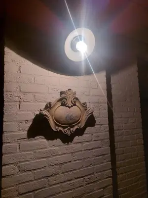 a light on top of a white brick wall at Guesthouse 66 in Lommel
