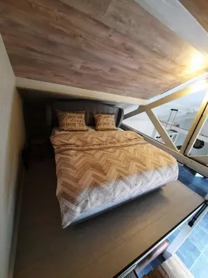 a bed in the middle of a room on a yacht at Guesthouse 66 in Lommel