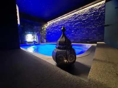 a vase sitting next to a swimming pool at night at Le Clos des Thermes in Chaudfontaine