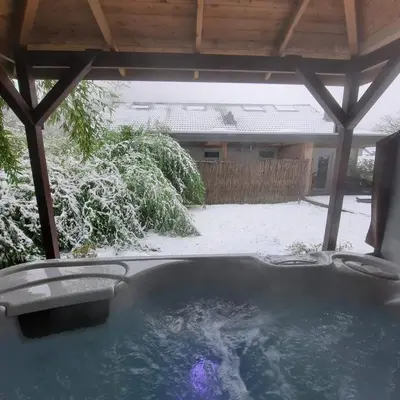 a hot tub in a yard covered in snow at Le Clos des Thermes in Chaudfontaine